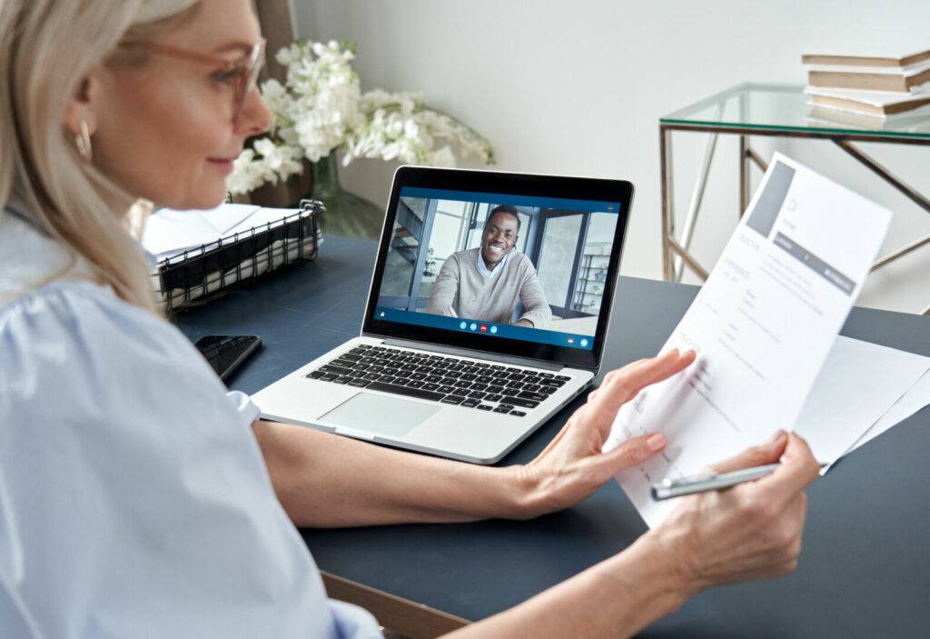 photo : Female hr reading cv during online virtual job interview by video call.