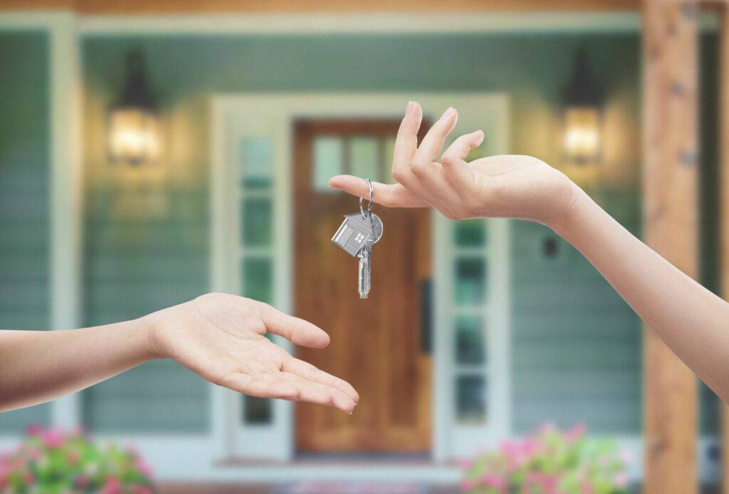 photo : Mani con chiavi con sfondo porta di casa