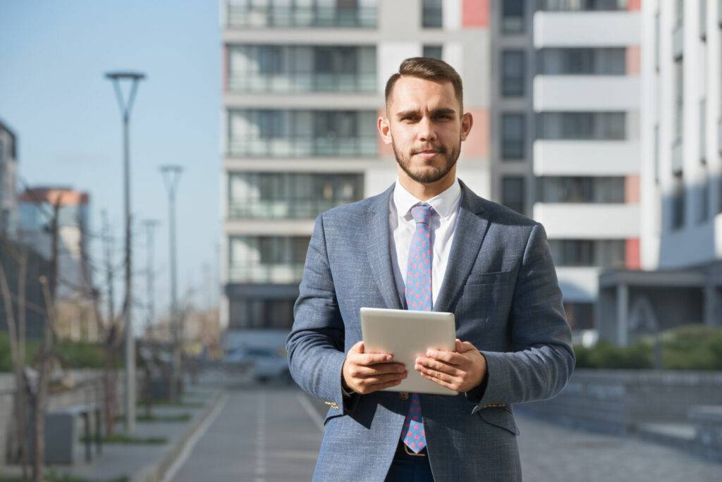 photo : Businessman or real estate agent with tablet computer against new building
