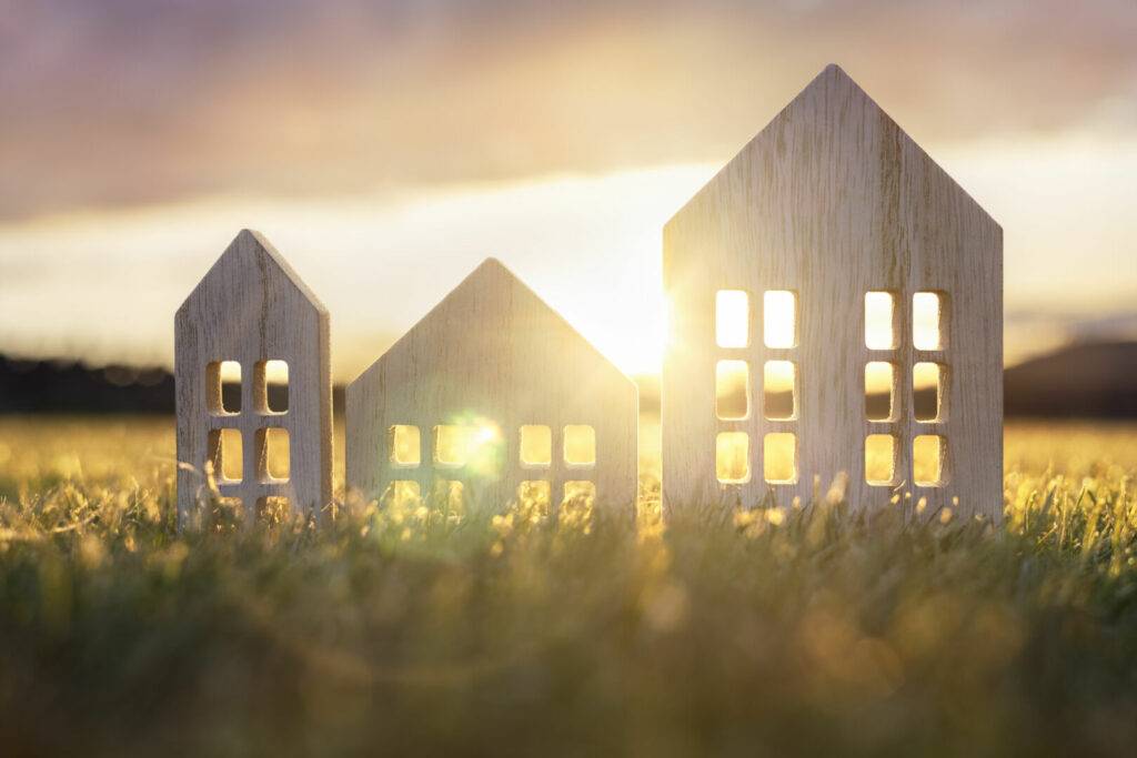 photo : Ecological wood  model house in empty field at sunset