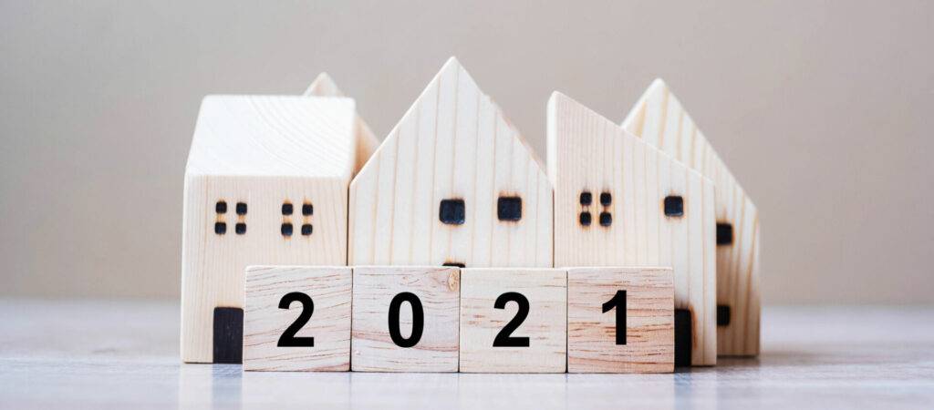 photo : 2021 Happy New Year with house model on table wooden background. Banking, real estate, investment, financial, savings and New Year Resolution concepts