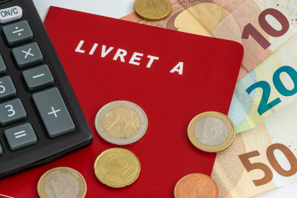 photo : Livret A avec pièces et billets en euros et une calculette. Le
