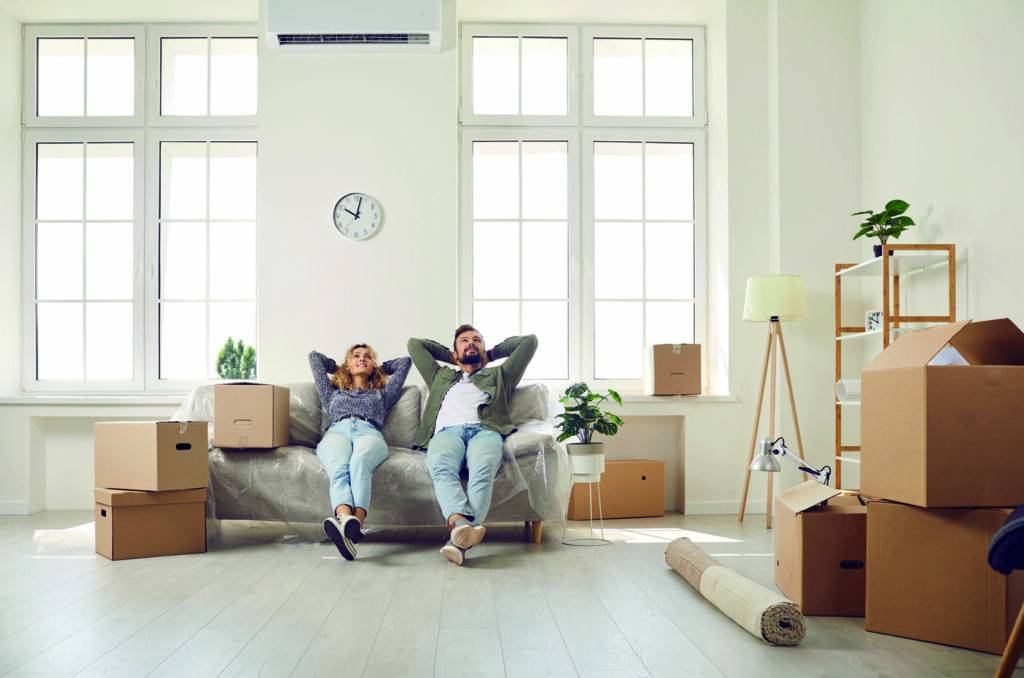 photo : Happy couple take break and sit on couch while moving in their newly bought house