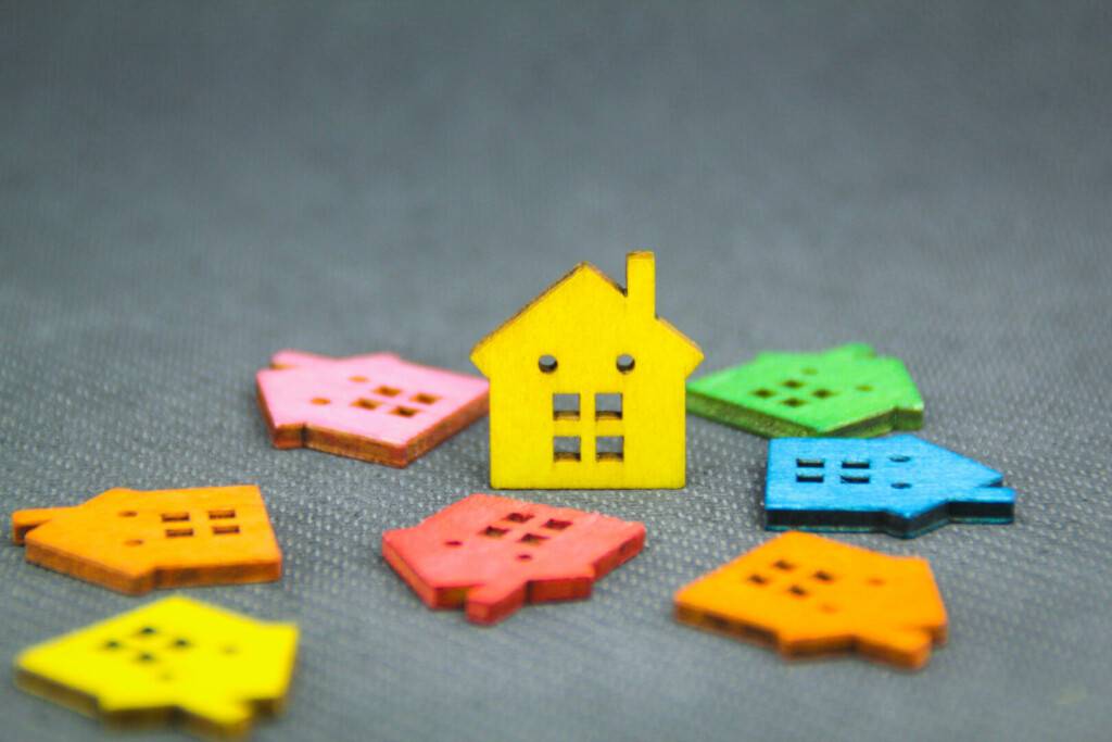 photo : a model of a colored wooden house with the concept of a housing crisis