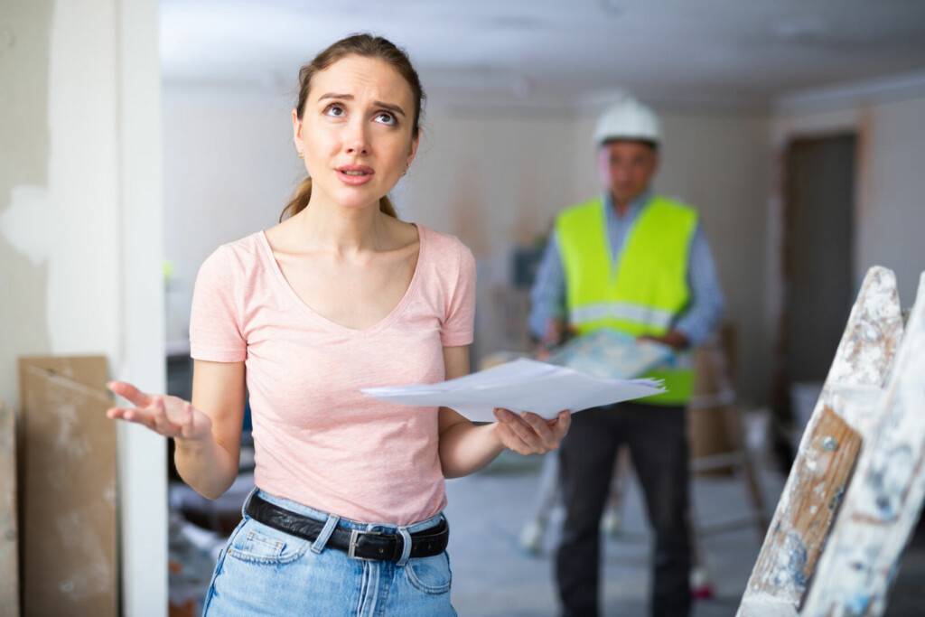 photo : Annoyed woman architect standing at renovating object