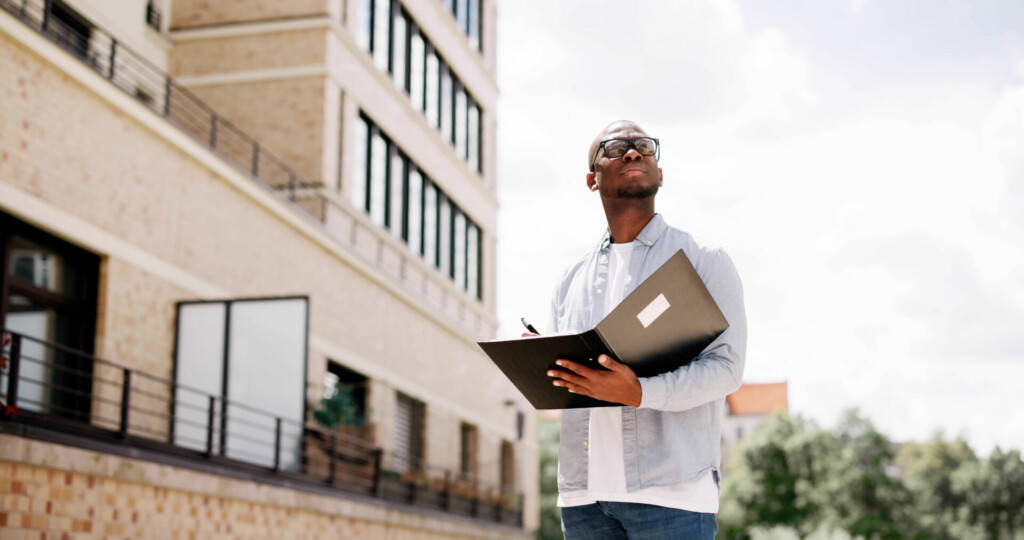 photo : Young African American real estate agent inspects beachfront property