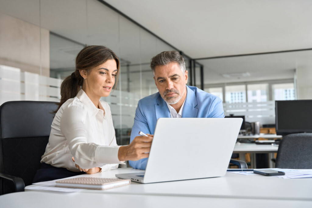 photo : Two busy executive team business people working on computer at office meeting.