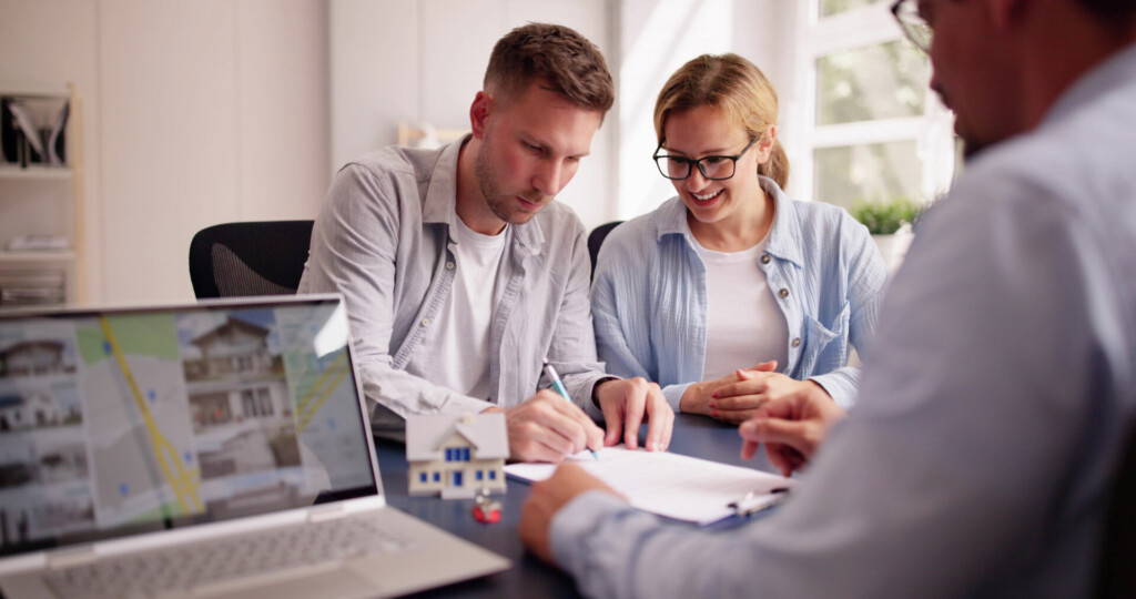 photo : Happy Hispanic Real Estate Agent Shows House to Young Latinx Couple on Laptop