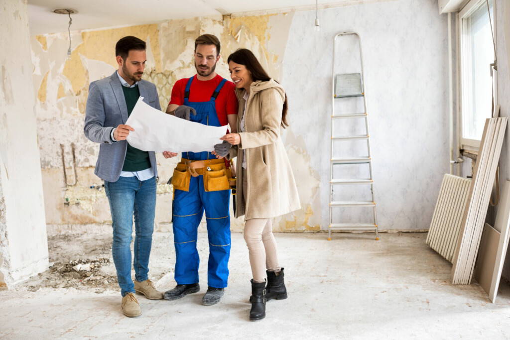 photo : Beutiful young couple looking blueprints of their home with hand