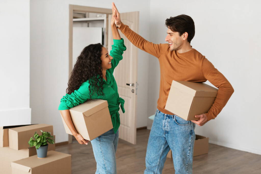 photo : Happy man and woman giving high five celebrating moving day