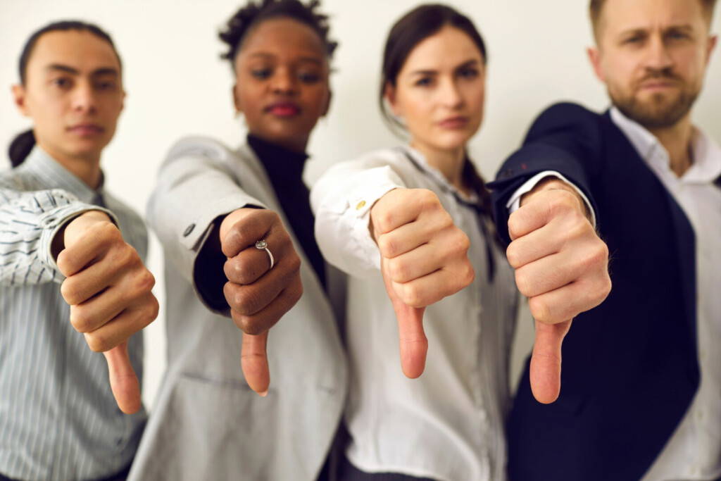 photo : Group of diverse business people giving thumbs down showing dislike of bad work results