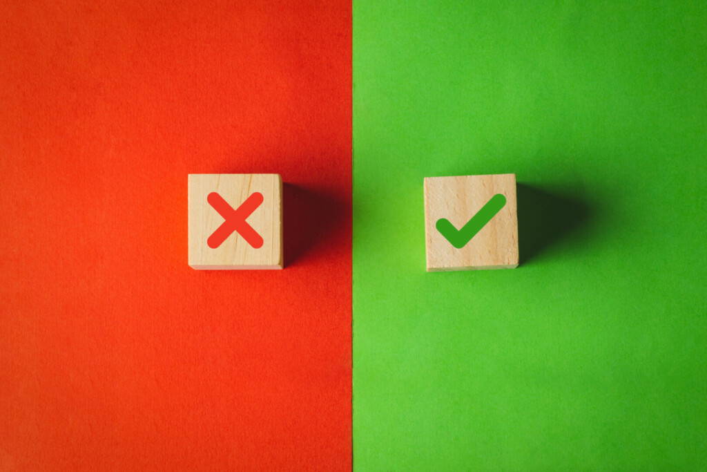 photo : True and false symbols, Yes or No on wood cubes on red and green background.