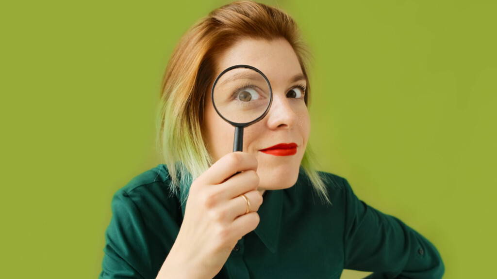 photo : Search. A young woman with a magnifying glass searches, investigates and studies.