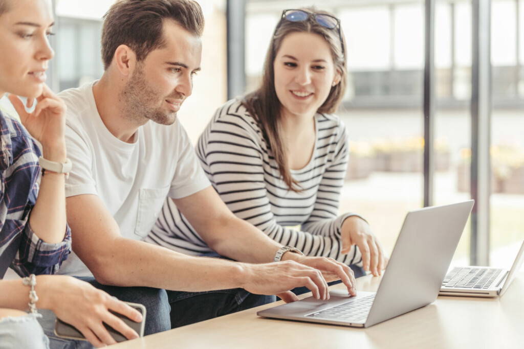 photo : cheerful-people-watching-laptop