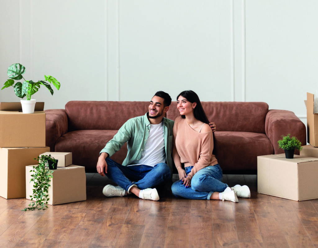 photo : Family relaxing on floor in new home with cardboard boxes